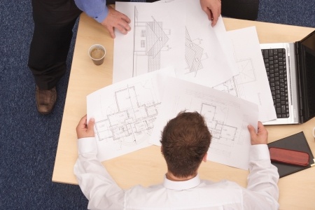 2137747 – two architects working on blueprints.