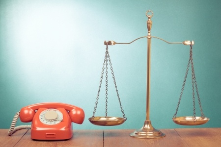 23950159 – law scales and retro telephone on table